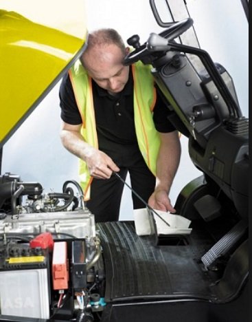 Technician performing maintenance on Clark forklift